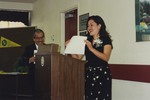 Woman at Lectern Holding up Certificate