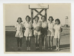 Young women standing in front of basketball goal