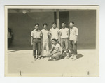 Six young men in front of barrack
